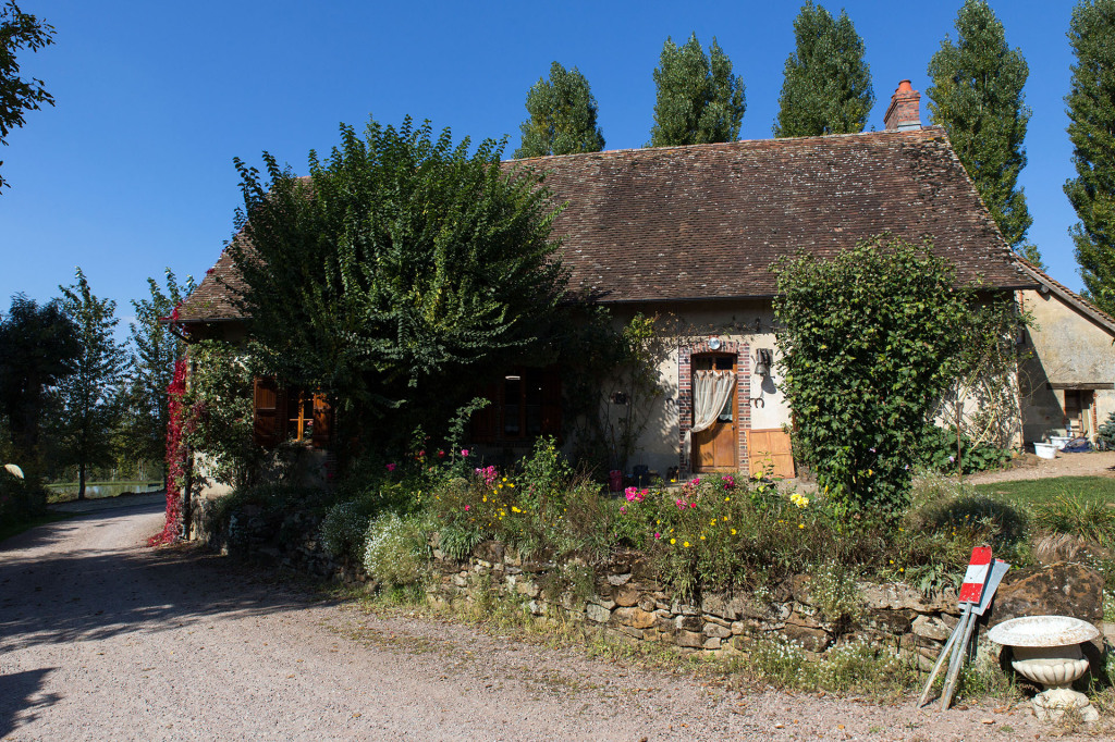 Une des jolies maisons de la ferme. On aperçoit l'étang au fond.