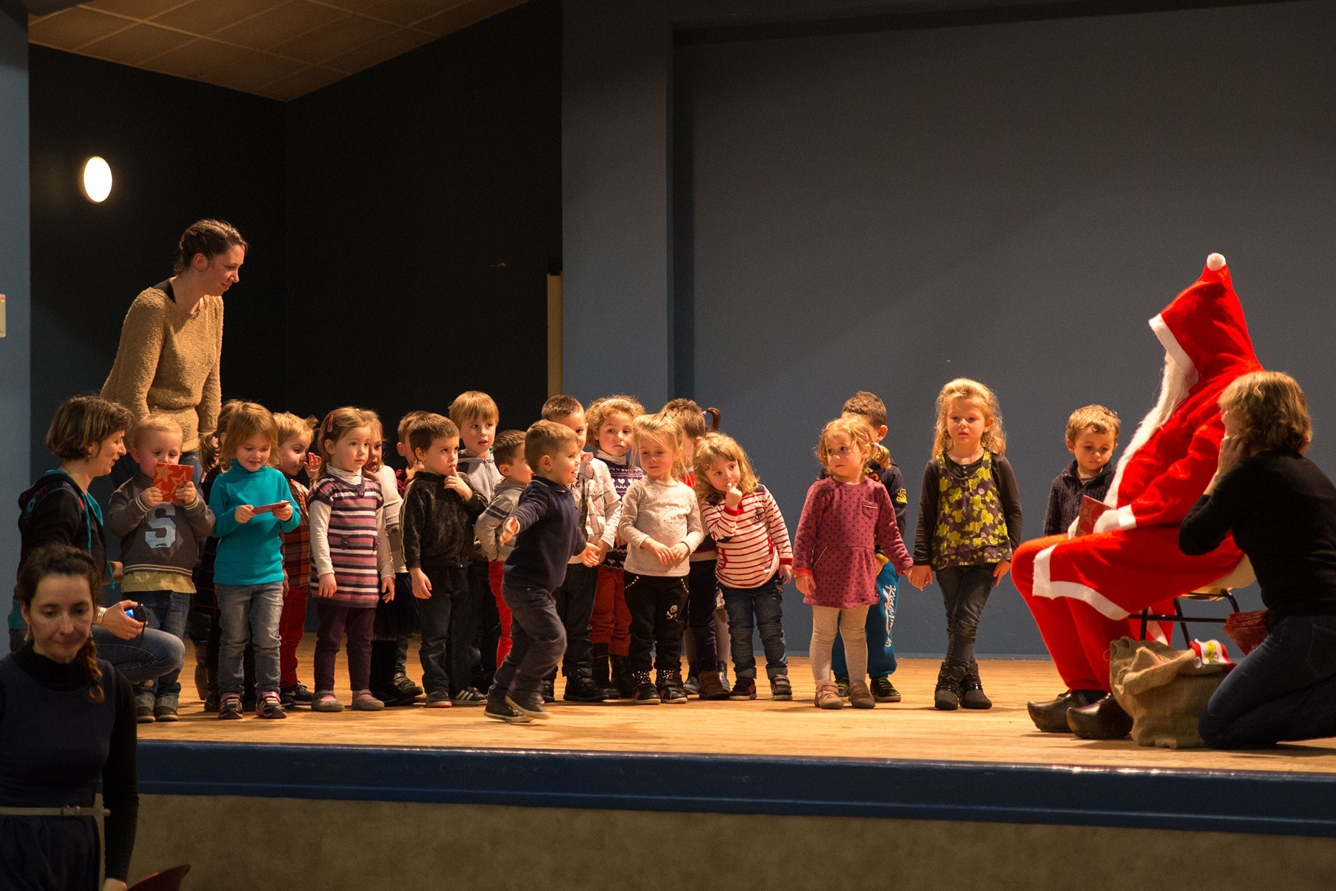 Les enfants font la queue pour recevoir leur cadeau du père Noël : c'est en fait un CD avec des histoires.