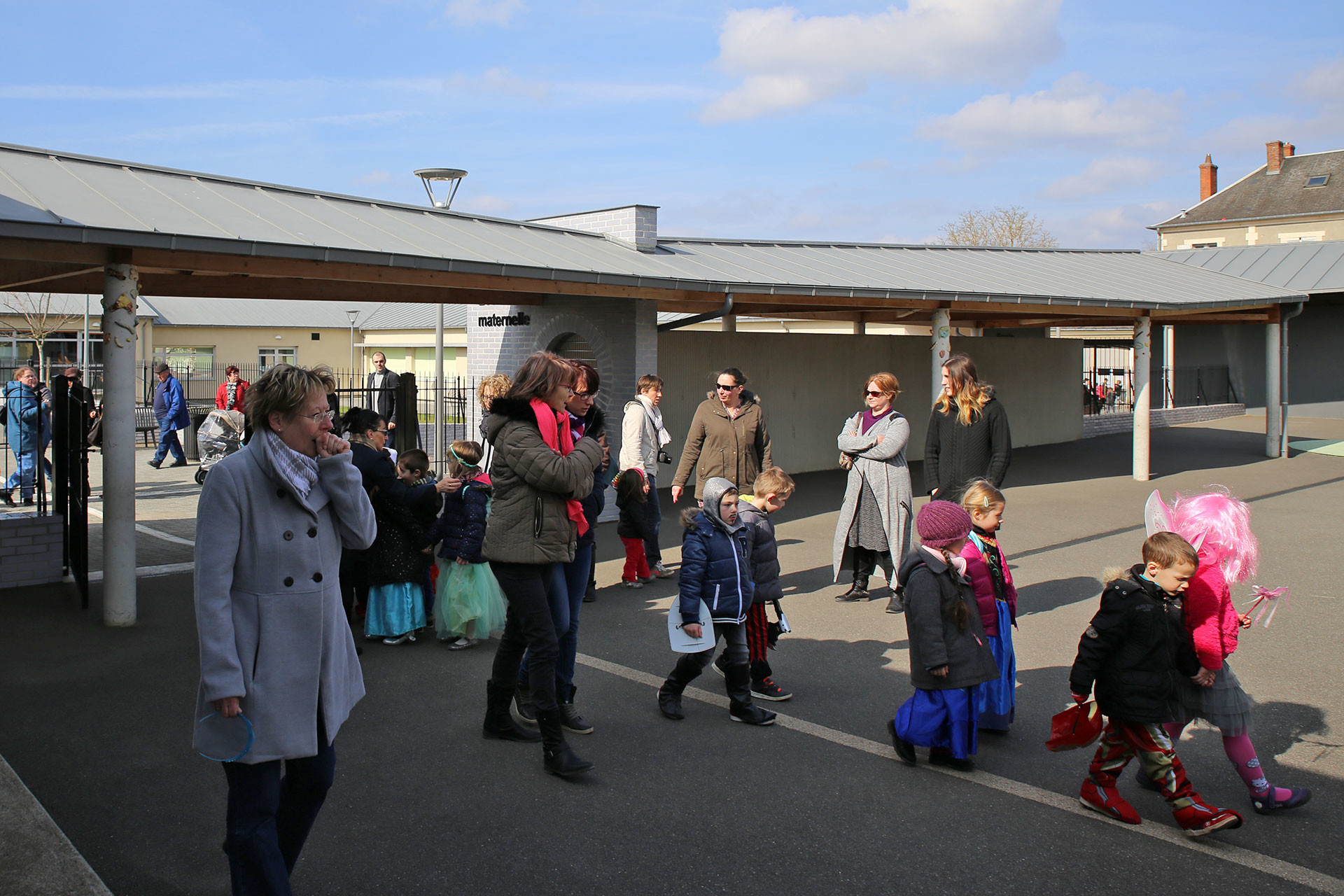 Les familles dévouées et désoeuvrées attendent dans la cour que les petits carnavaliers retirent leurs manteaux...